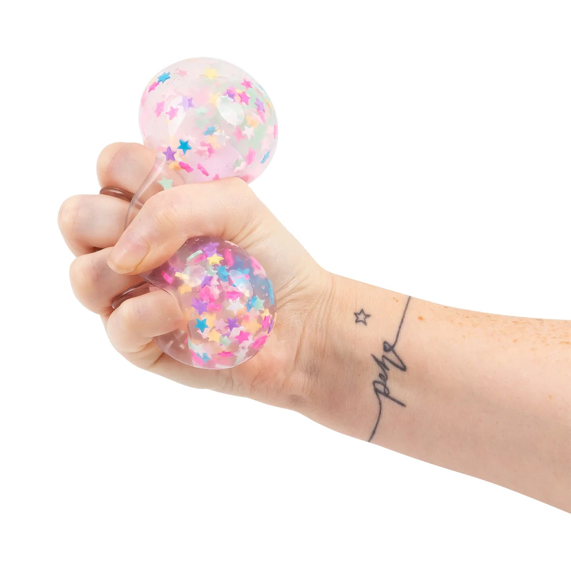 Hand holding a clear stress ball with colorful confetti inside on a white background