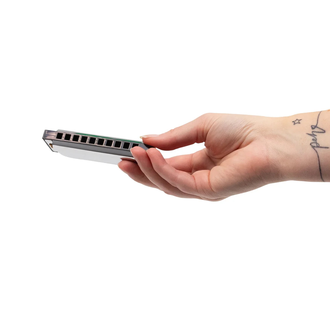Hand holding a silver and black rectangular harmonica against a white background