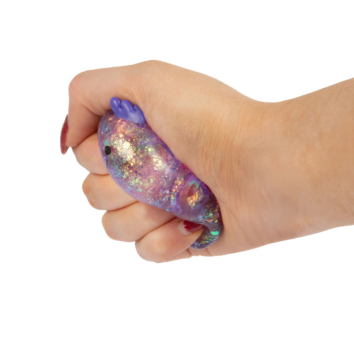 Hand holding a colourful glittery stress mini sugar axolotl against a white background