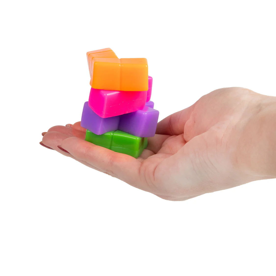 Hand holding a stack of colorful squishy puzzle cubes on a white background
